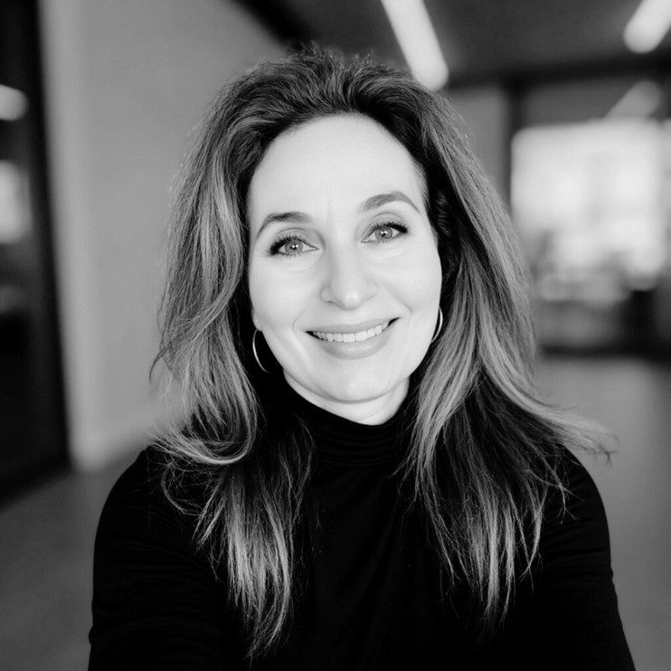 Black and white portrait of a smiling woman with long hair.